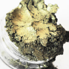 Eye shadow powder, golden green, textured, in a clear jar, close-up view
