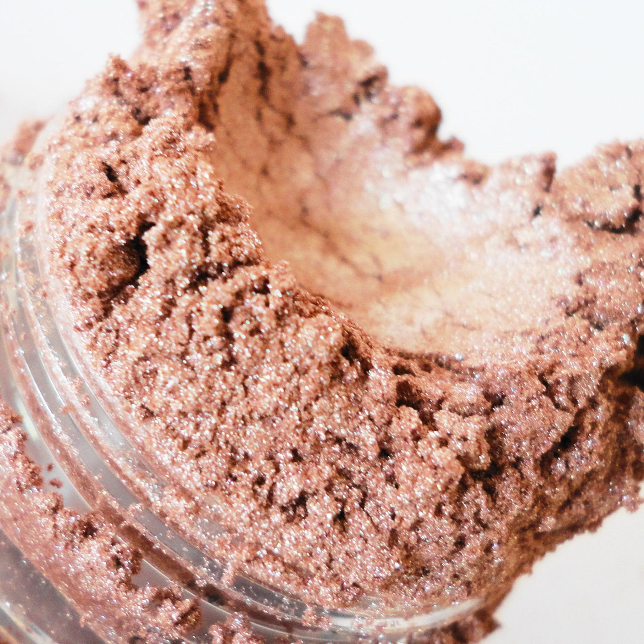 Side view of taupe brown shimmer eyeshadow in sifter jar showing luster texture and smokey effect