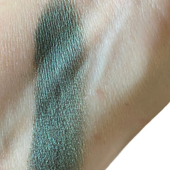 Close-up of teal green metallic eyeshadow with shimmer luster in sifter jar, showcasing mineral texture