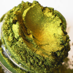 Green and gold powder with glittery texture in a clear container