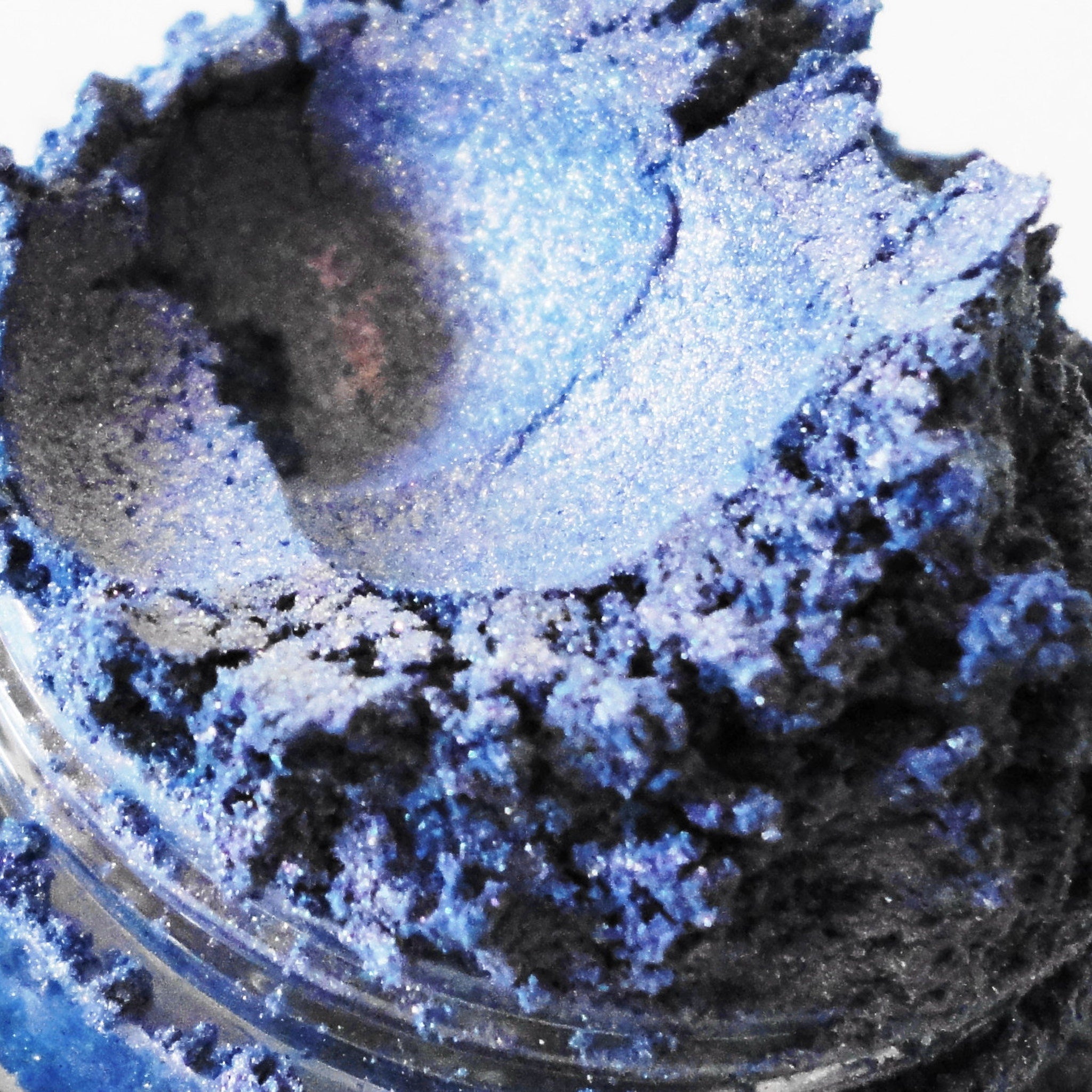 Blue eyeshadow powder with shimmer, dark and light hues, in a jar