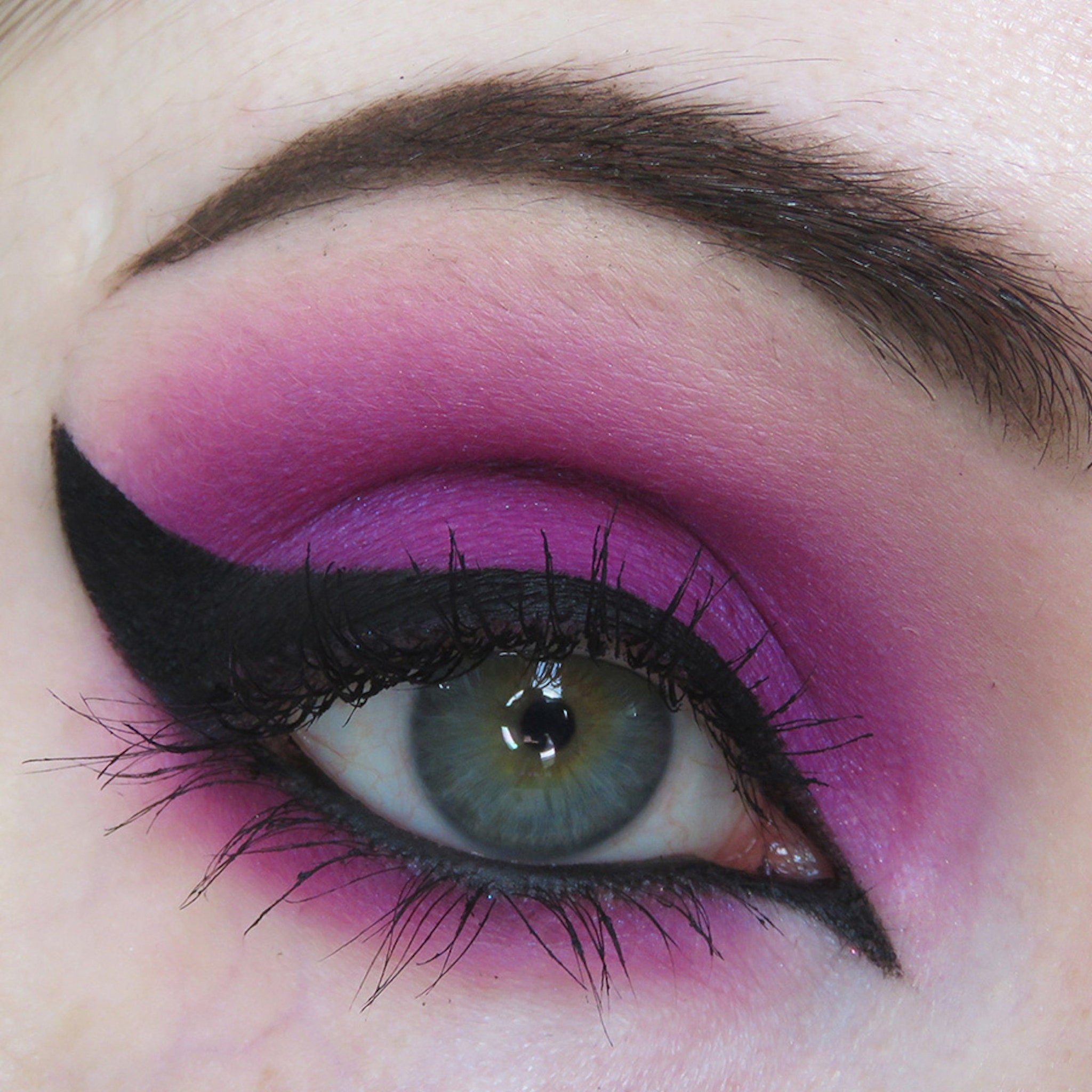 Eye makeup with pink eyeshadow, black eyeliner, and long black eyelashes