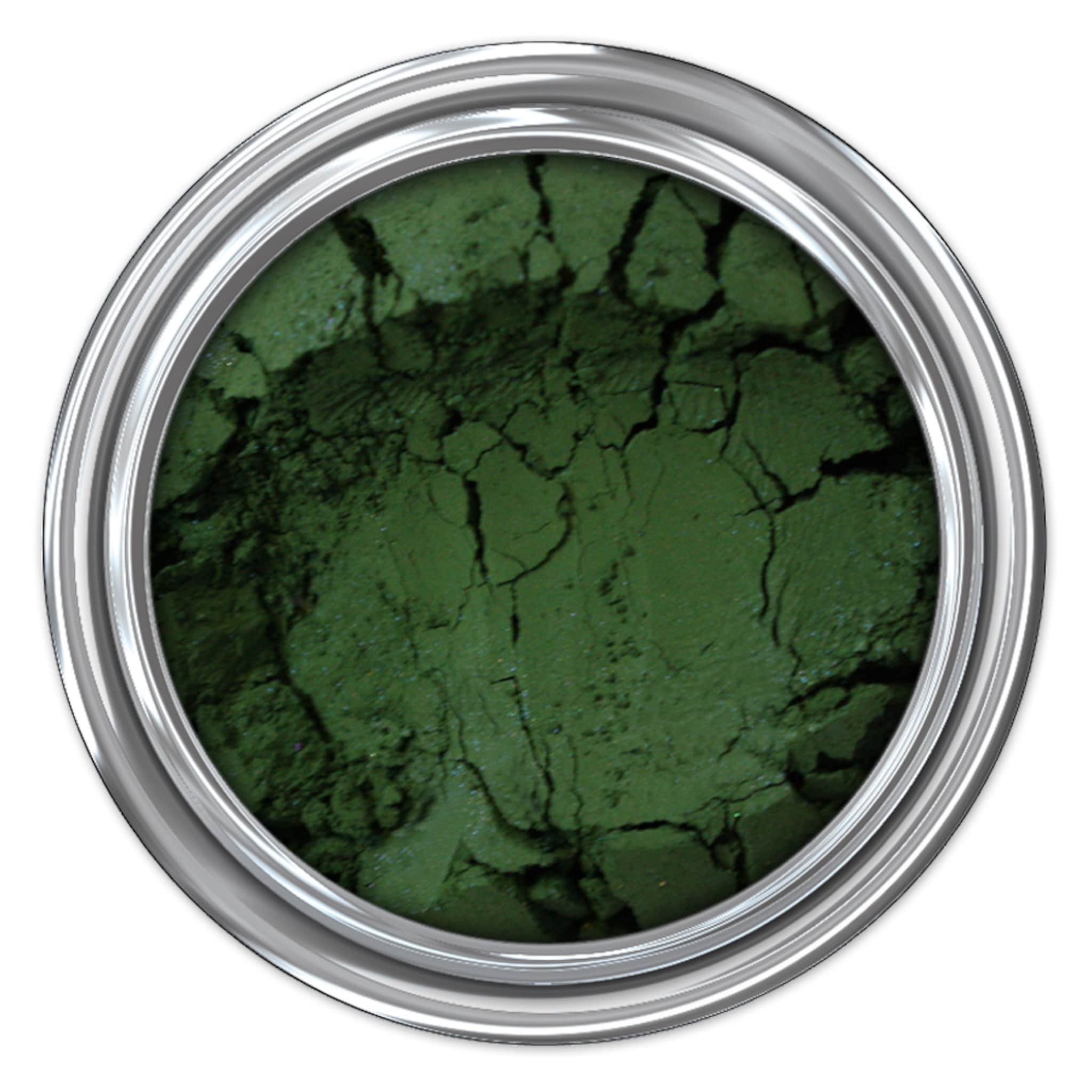 Green powder in silver metal container, cracked texture, top view