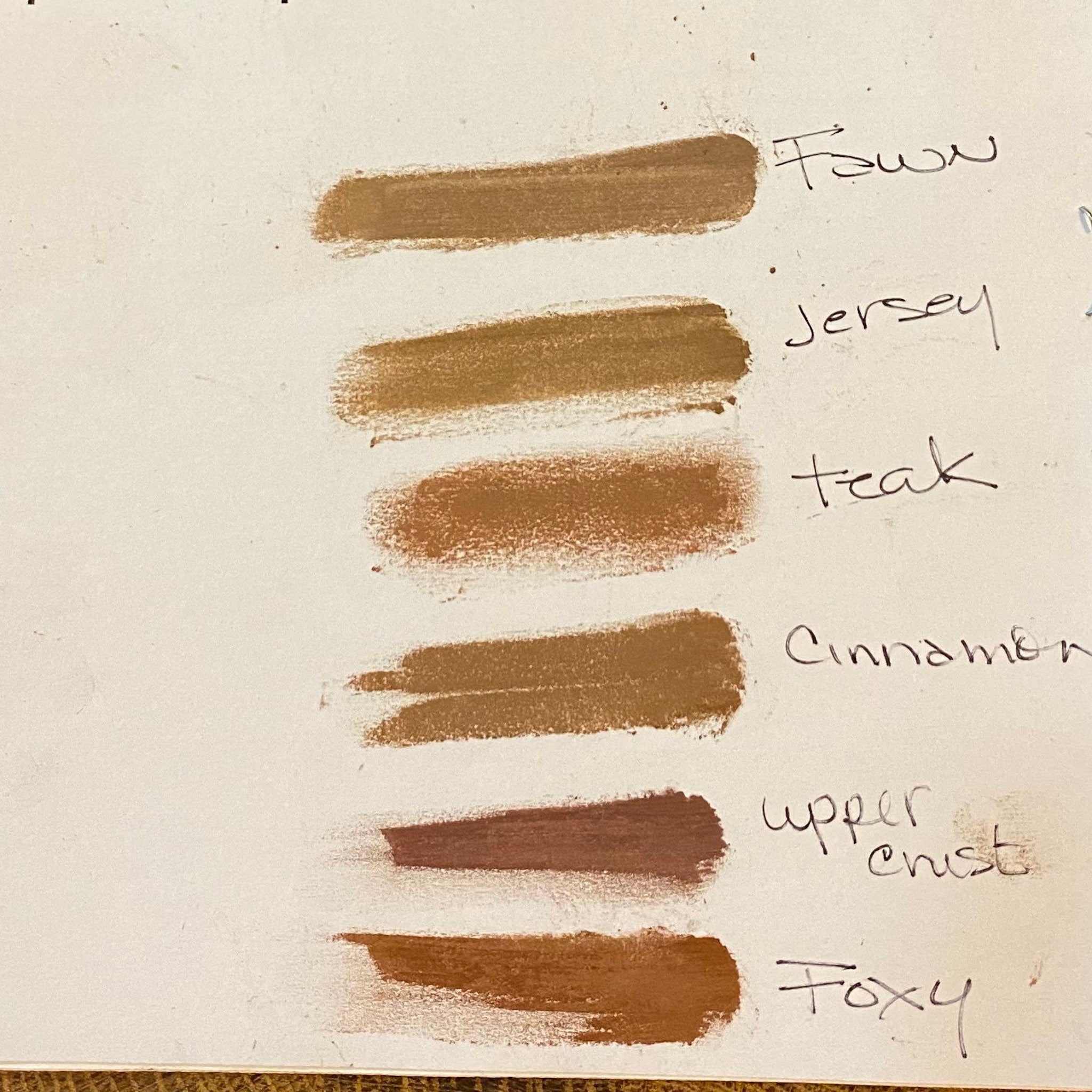 Hand applying matte taupe and light reddish brown mineral eyeshadow with fingertip for natural makeup look