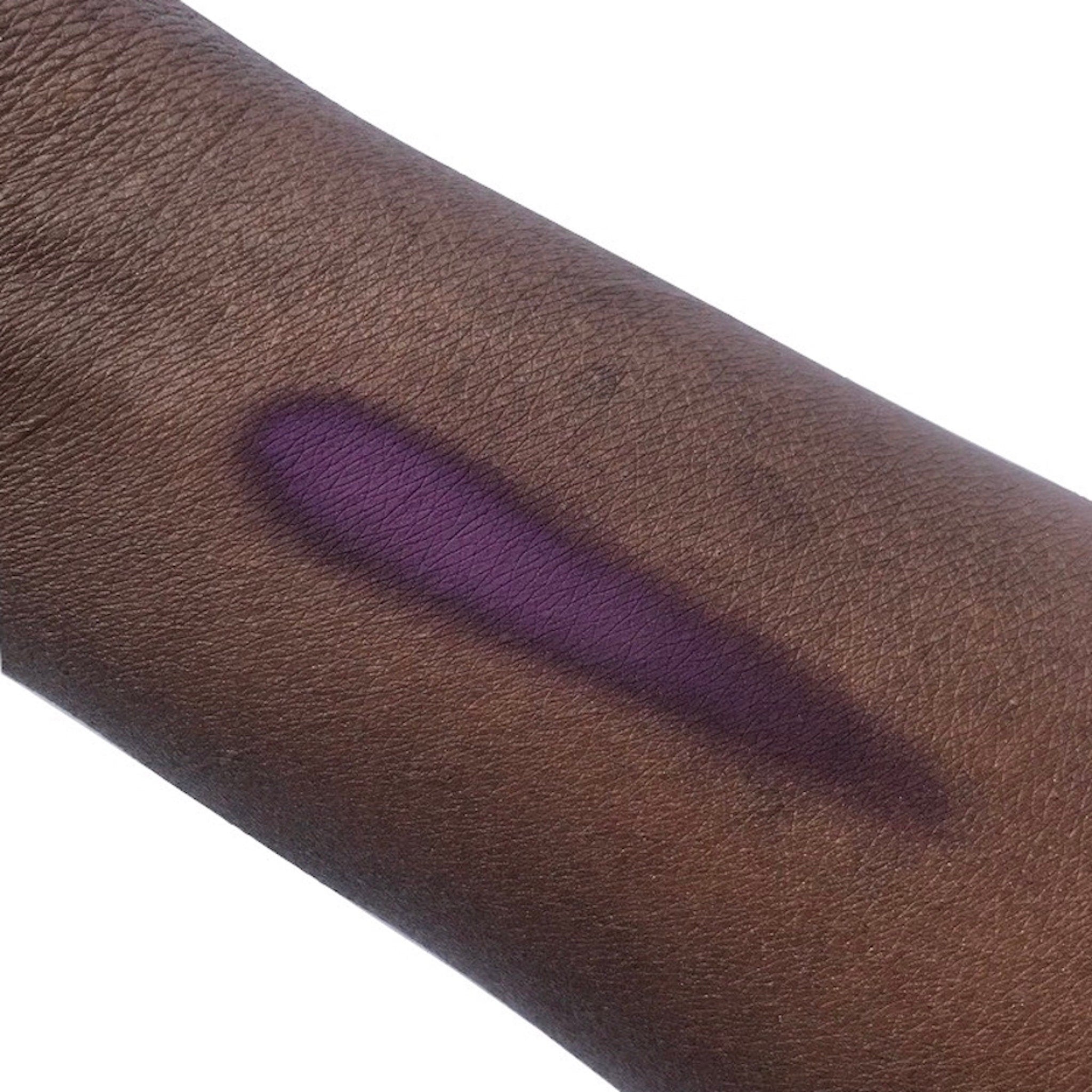 Close-up of a makeup brush applying matte taupe eyeshadow to eyelid for a smooth, crease-free finish