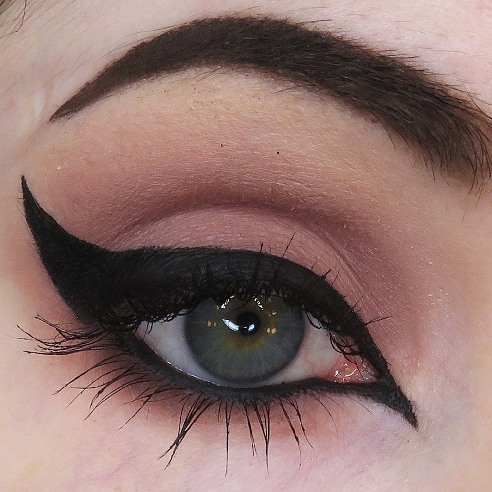 Eyeliner makeup with black winged liner, dark lashes, and eyeshadow on eye