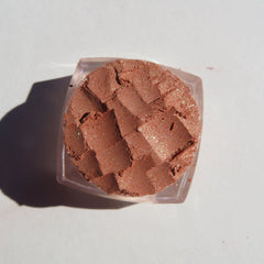 Close-up of loose brown gold mineral eyeshadow with intense golden shimmer particles, vegan and cruelty-free