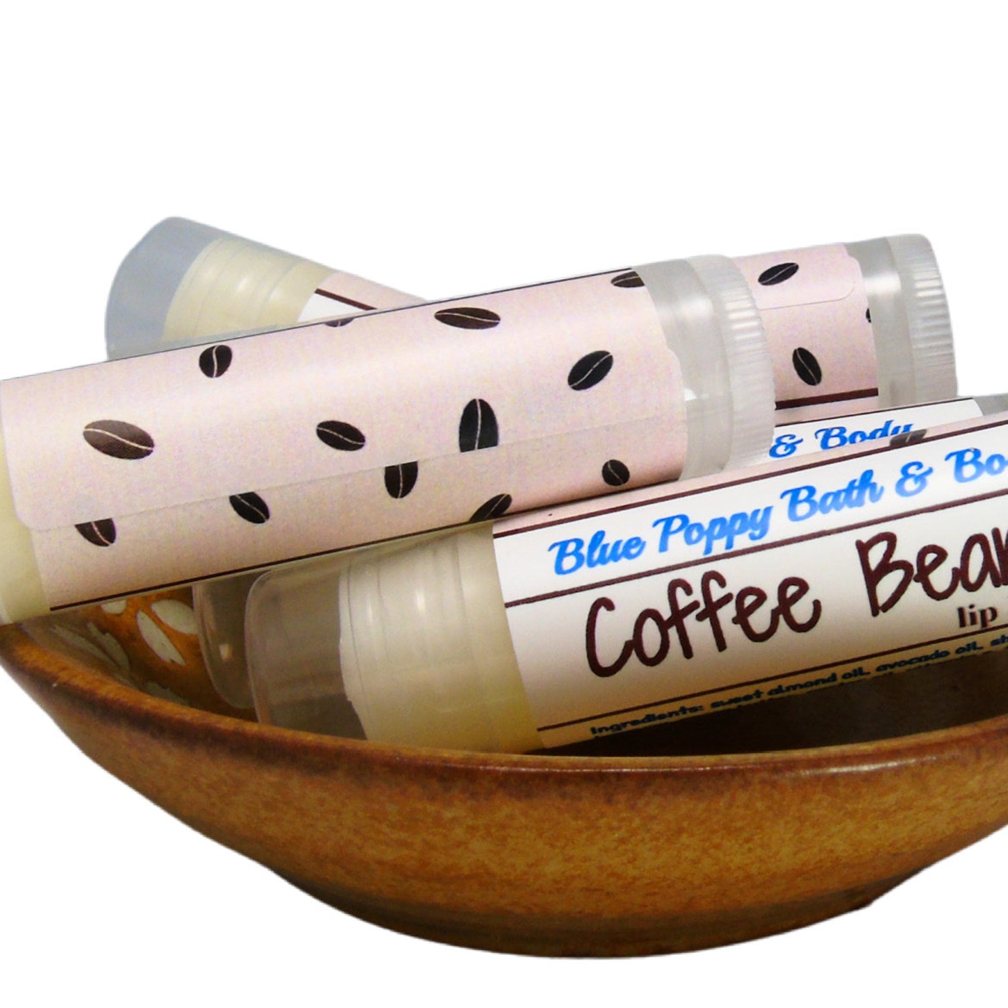 Lip balm tubes with coffee bean pattern on label, in wooden bowl, Blue Poppy brand