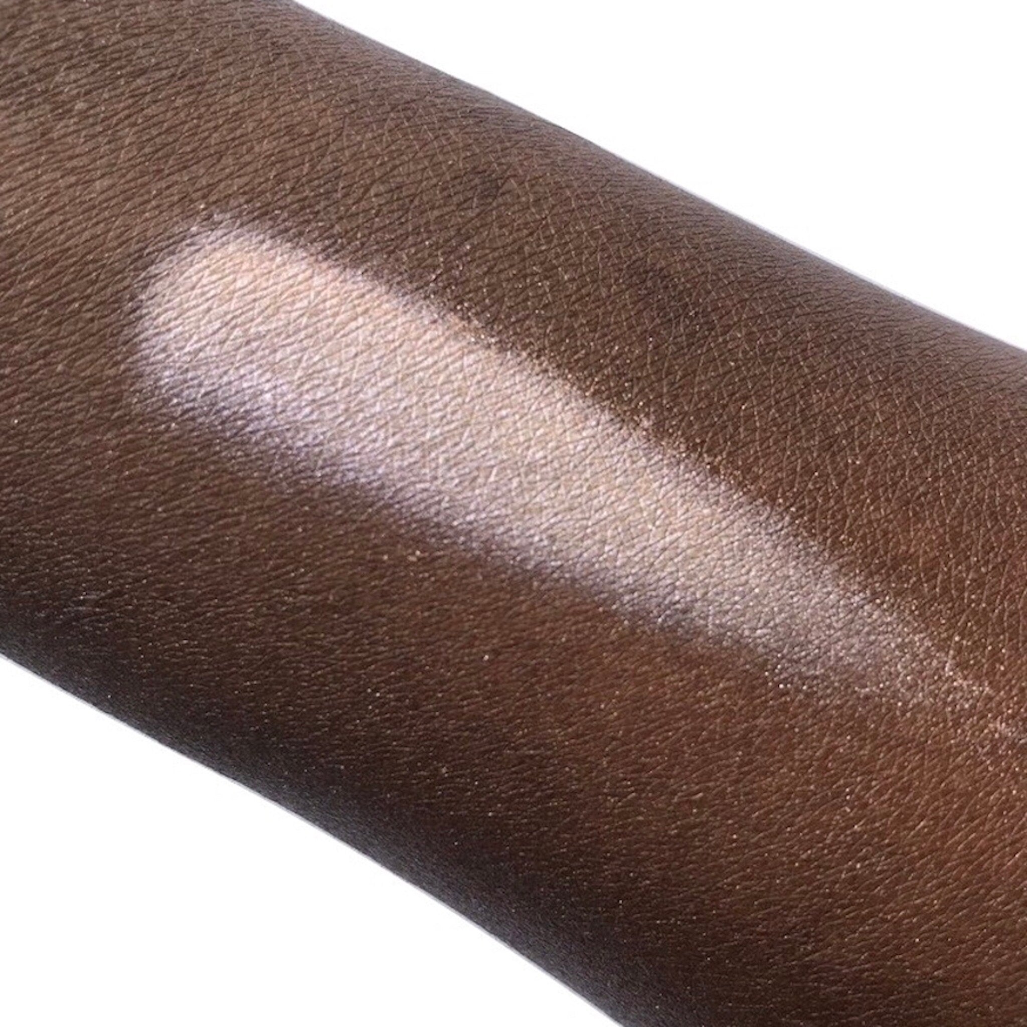 Hand applying shimmery taupe mineral eyeshadow with fingertip for a smooth, crease-free finish