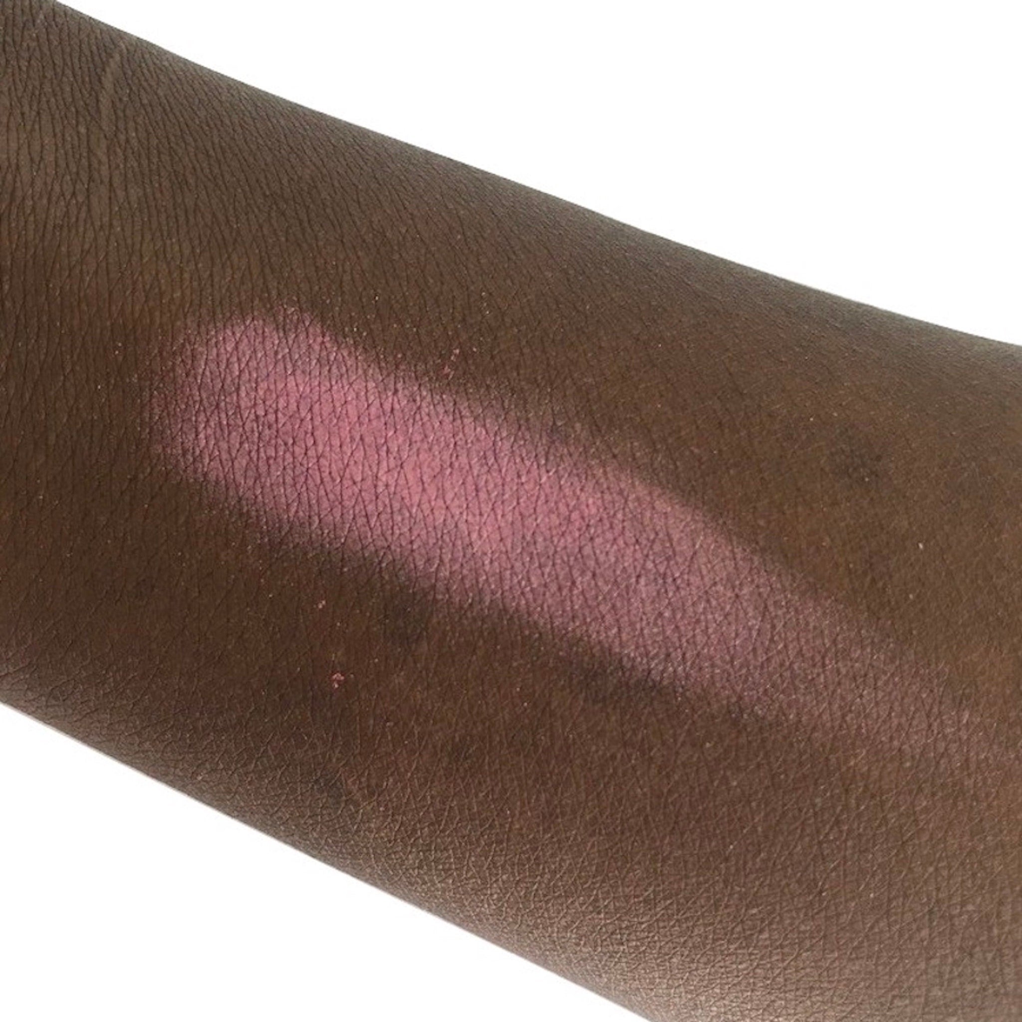 Blush swatch on arm, pink powder, skin tone test, visible texture