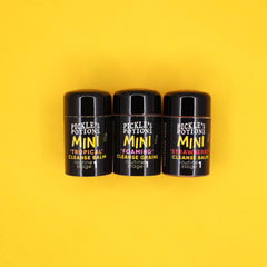 Mini cleanse balm bottles, black cylindrical containers, Pickle's Potions brand, yellow and white text labels