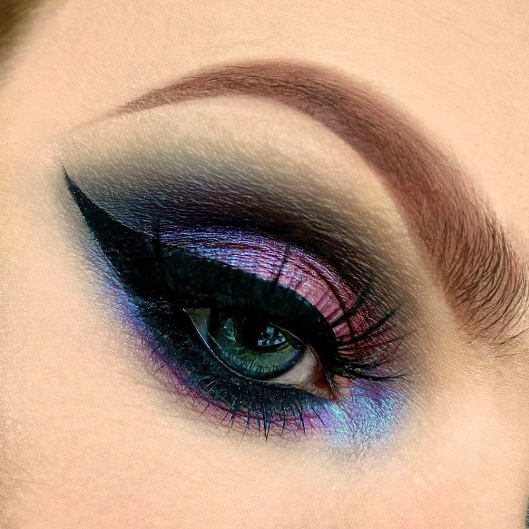 Eye makeup with black eyeliner, purple and blue eyeshadow, and dark eyelashes