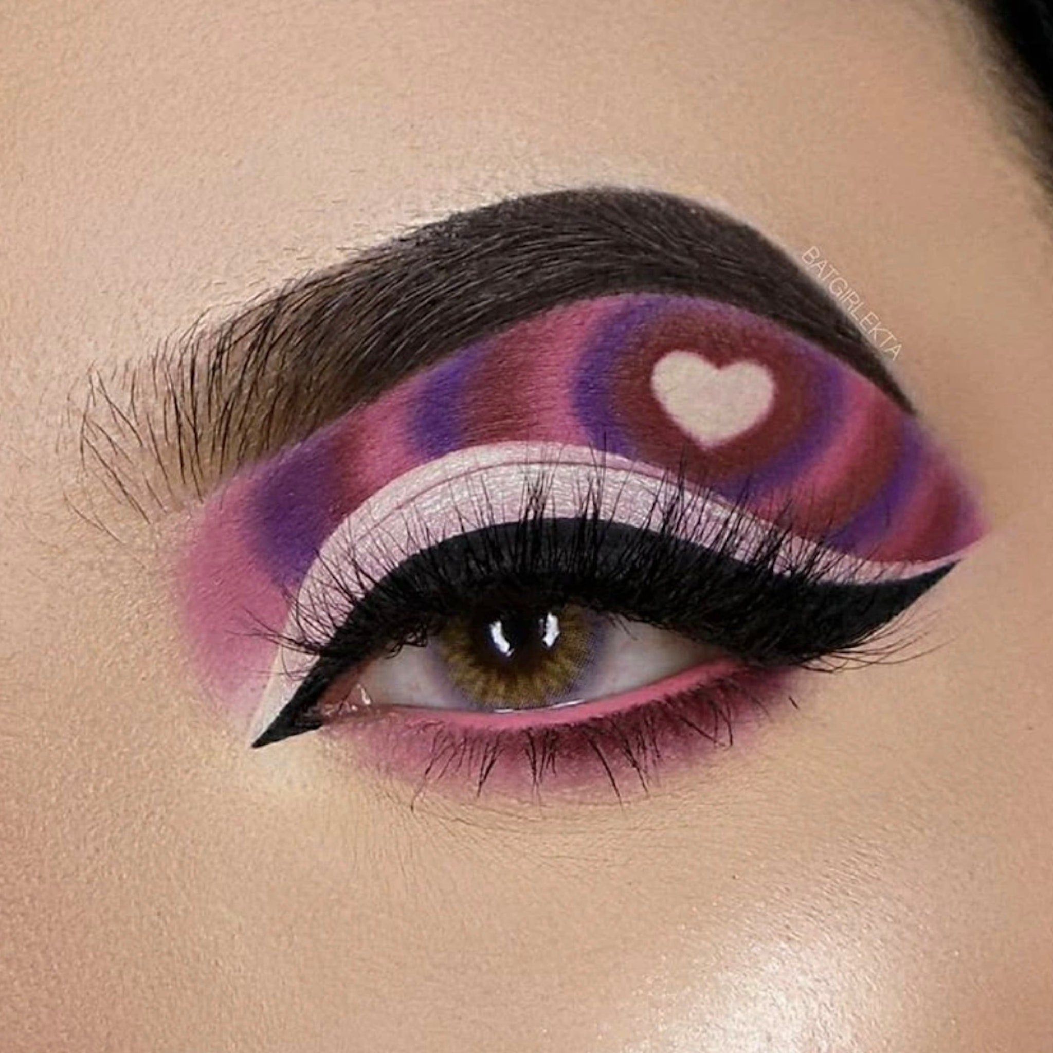 Eye makeup with purple, pink, and white swirl design, heart detail, and black eyeliner by BATGIRLEKTA