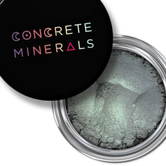 Vegan eyeshadow, metallic green powder, black lid with Concrete Minerals text, silver container