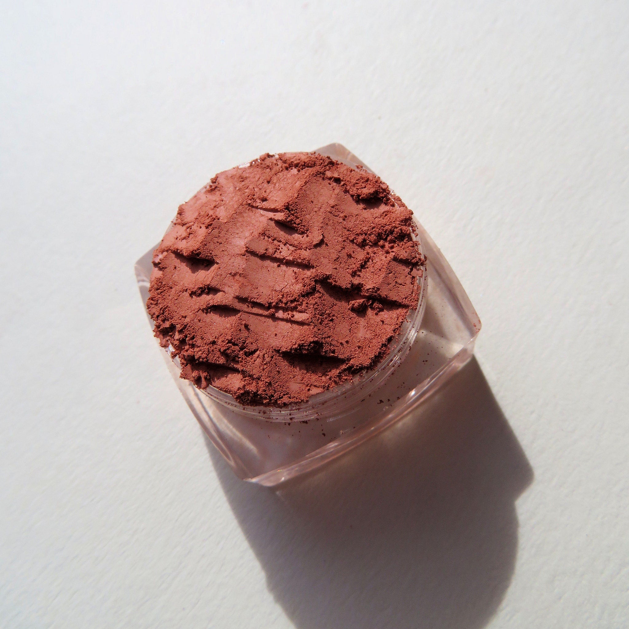 Open jar of Fire Witch burnt orange matte mineral eyeshadow with loose powder visible