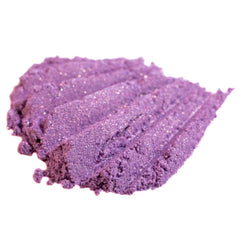 Purple eyeshadow swatch with glitter, textured surface, and light reflection