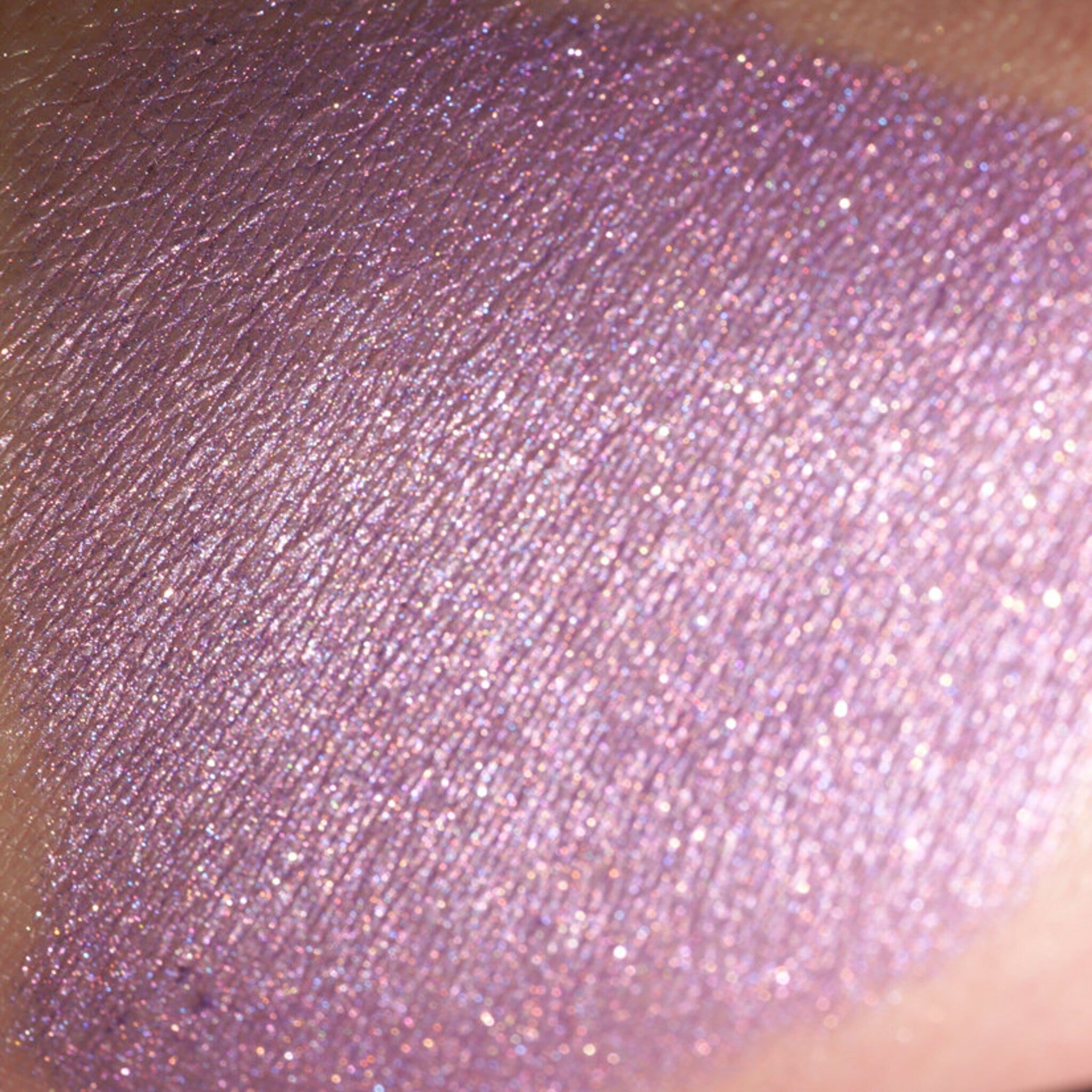 Glitter eyeshadow swatch in lavender with shimmer and textured finish on skin