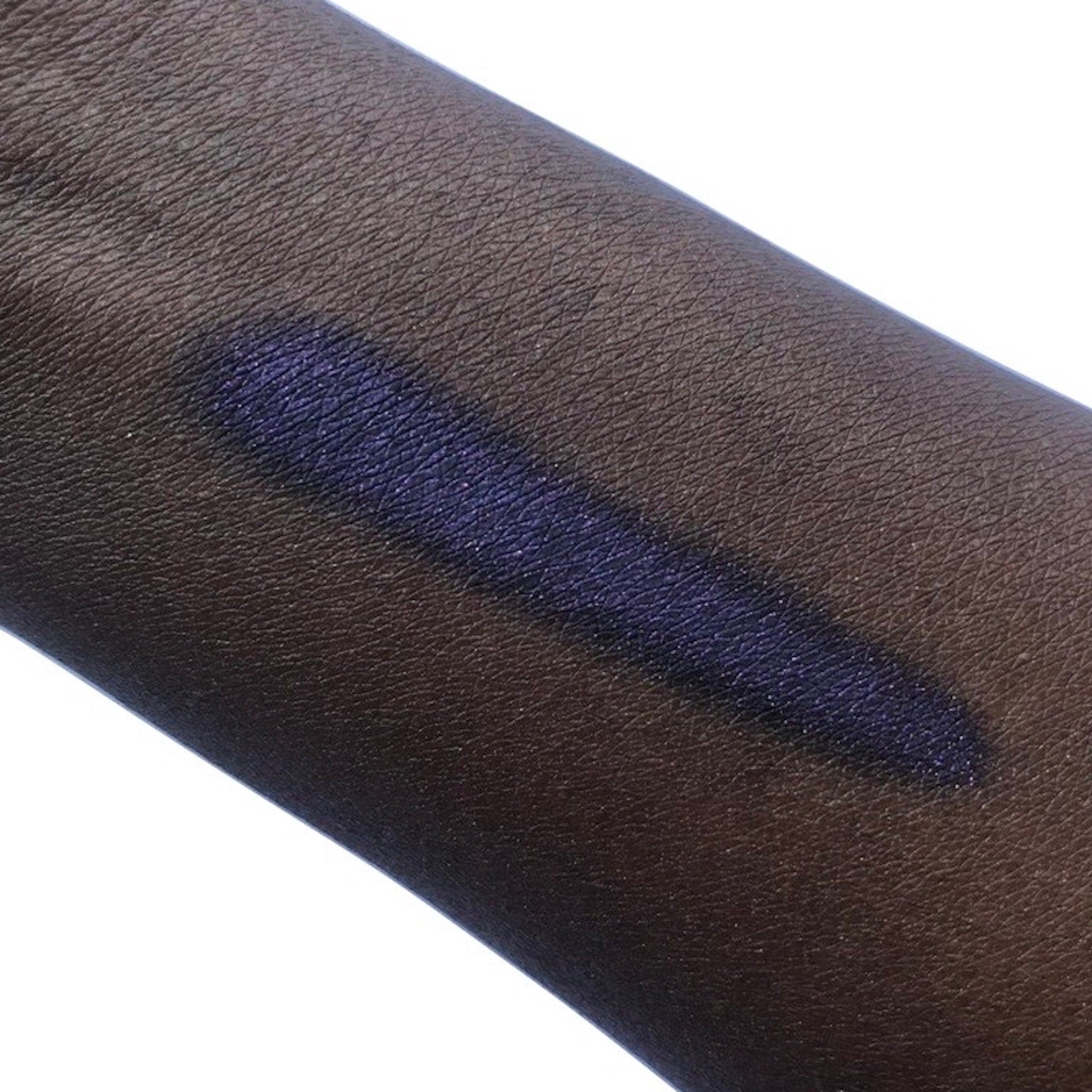 Purple eyeshadow swatch on dark skin, showing color and texture of product