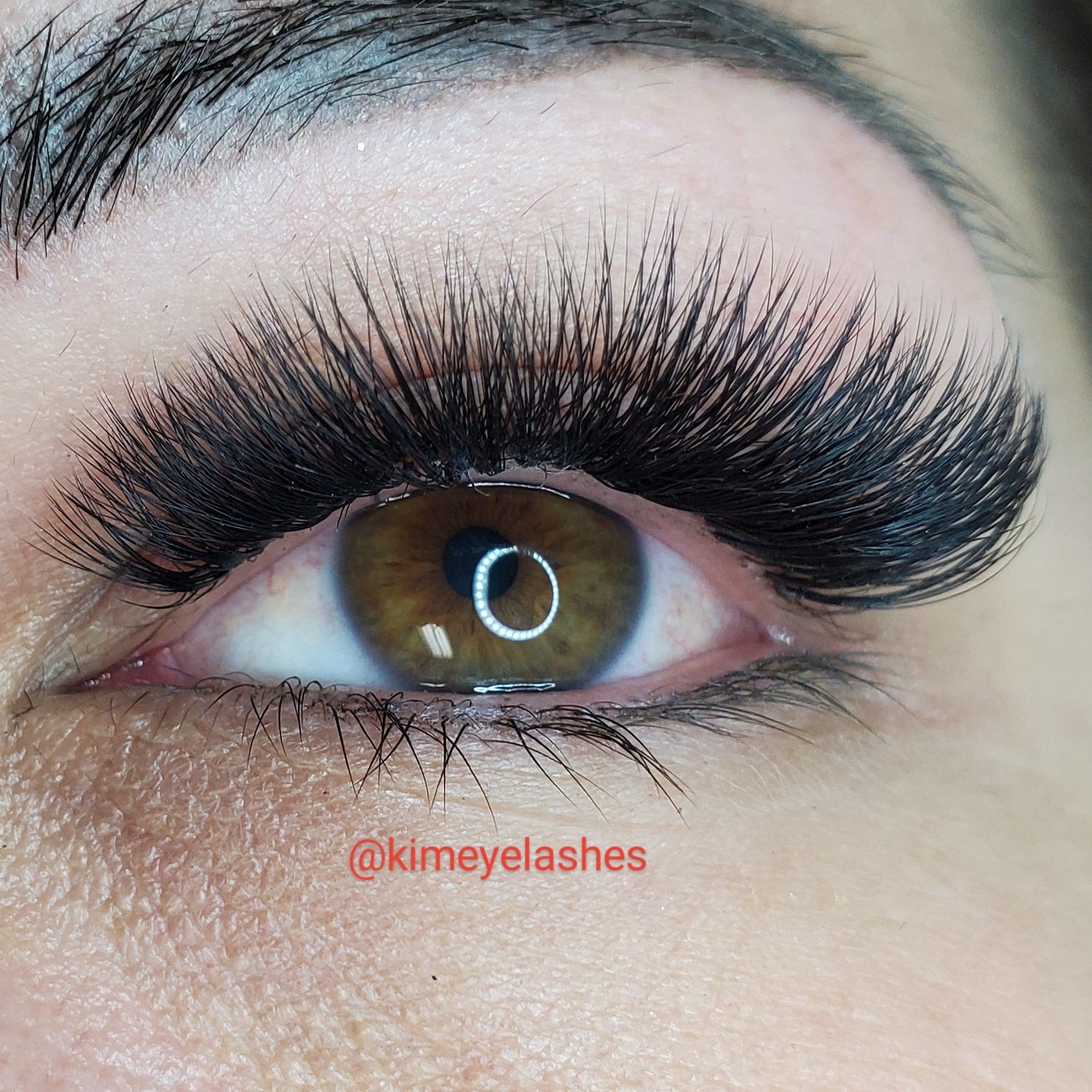 Eyelash extensions with black, curved lashes and visible eye, Kimeyelashes brand