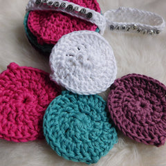 Crochet face scrubbies in pink, white, teal, and purple cotton, with beaded "NAMZSHINE" text