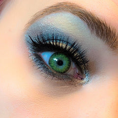 Green contact lens with black eyelashes and blue eyeshadow applied to eye