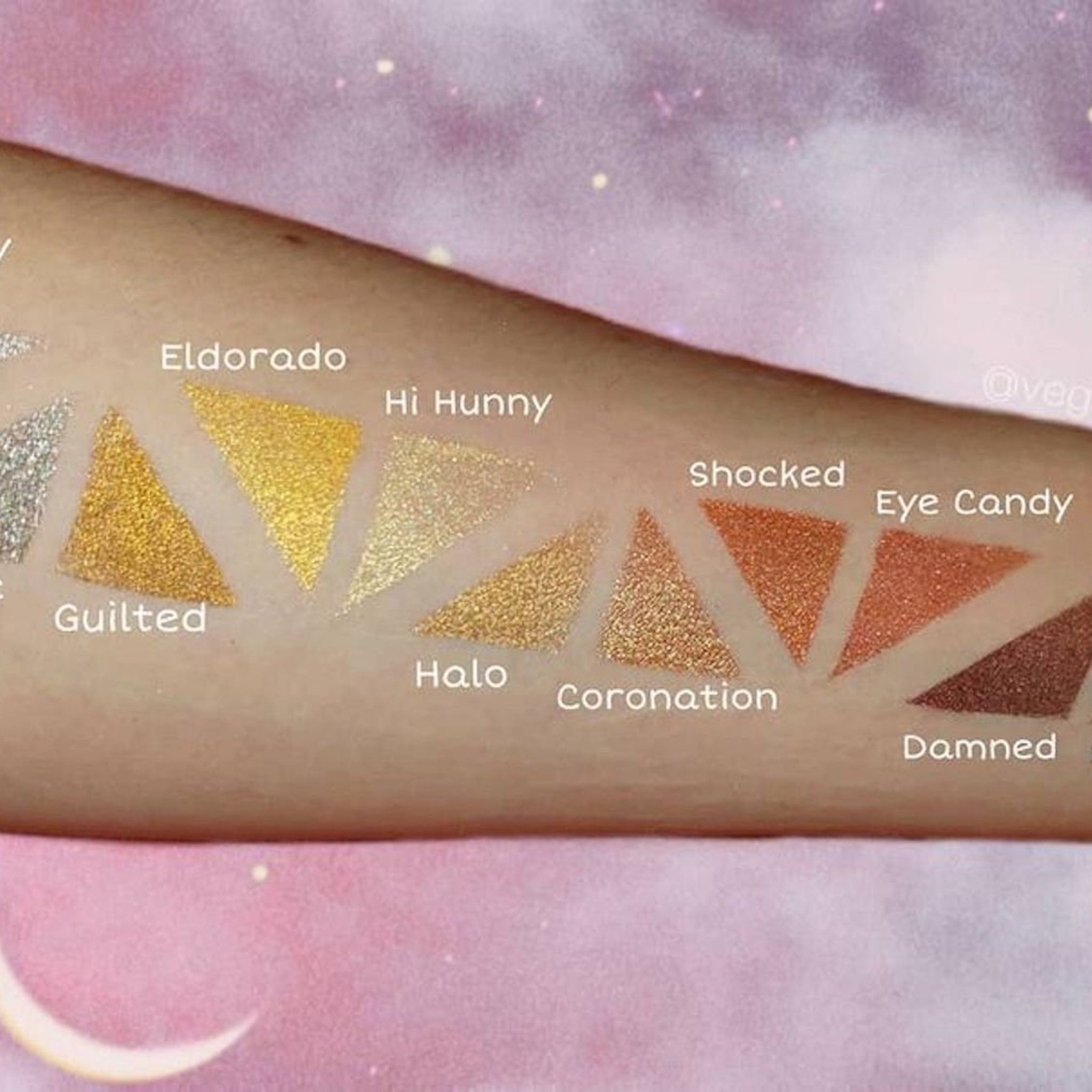Eyeshadow swatches in gold, copper, and brown shades on arm, with text labels