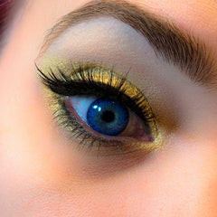 Blue eye contact lens with gold eyeshadow and black eyelashes, close-up view