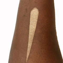 Eyeshadow swatch in metallic gold color applied on arm for testing