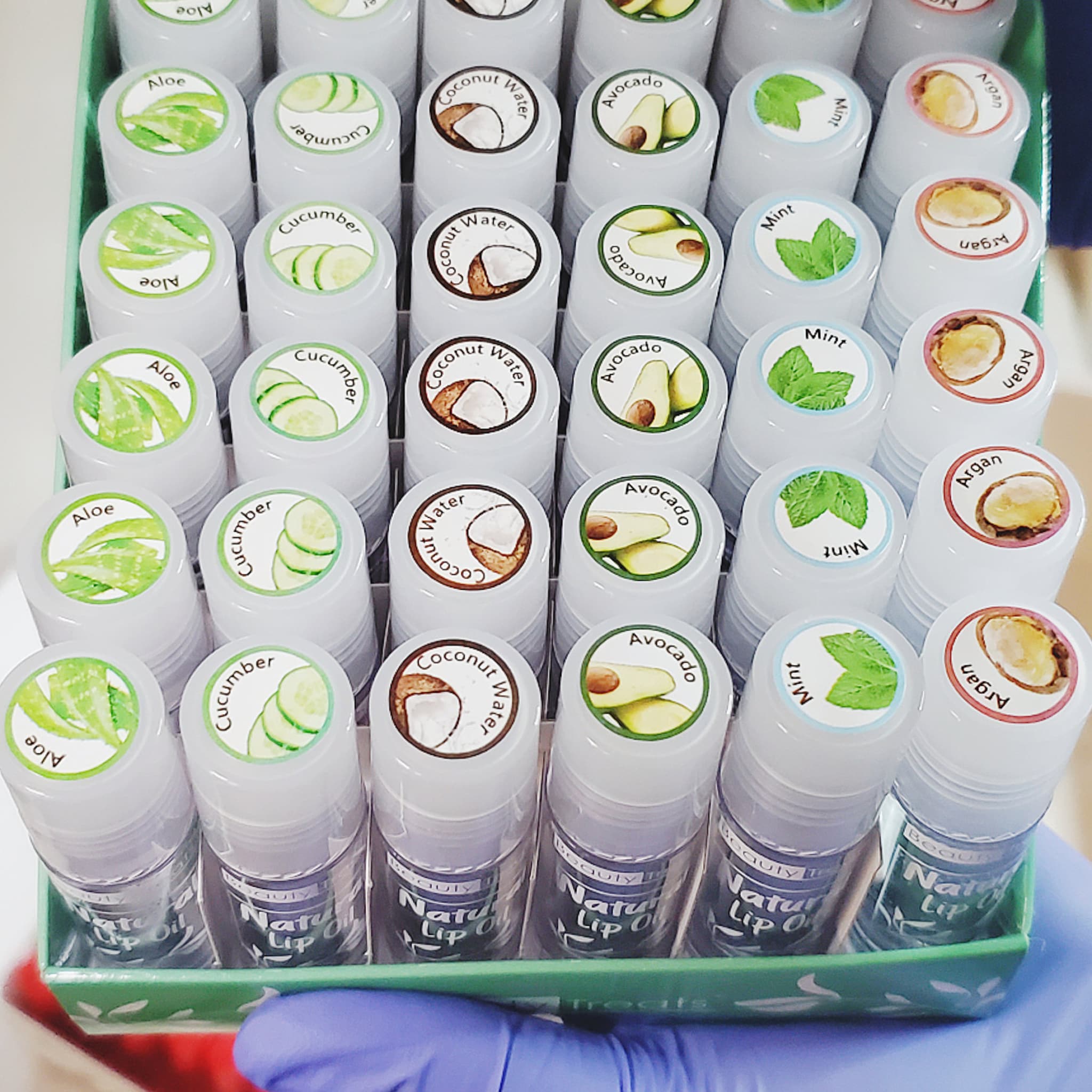 Lip gloss bundle, white tubes with colorful labels, Beauty Treats Natural Lip Oil visible