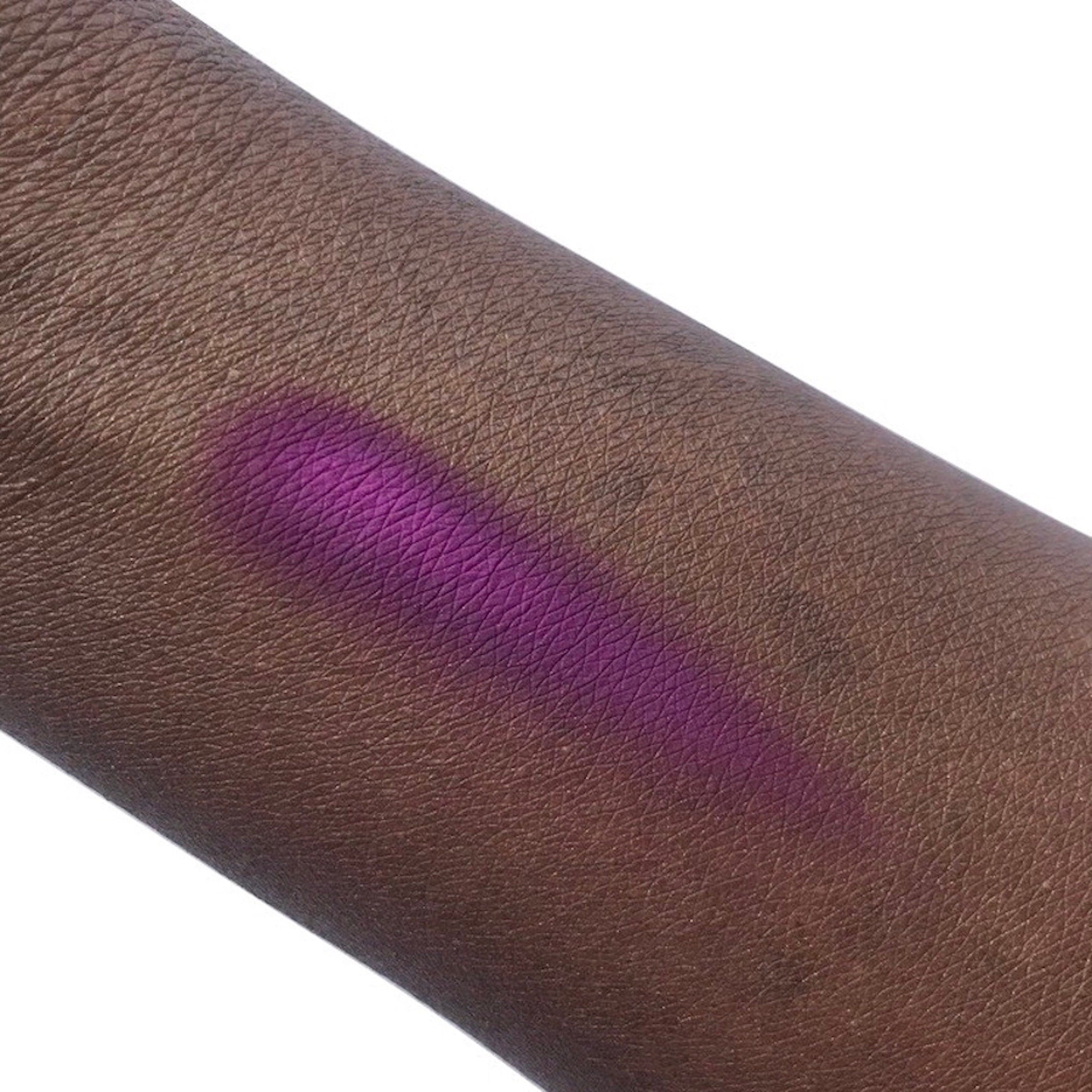 Purple swatch on dark skin, showing color and texture of skin