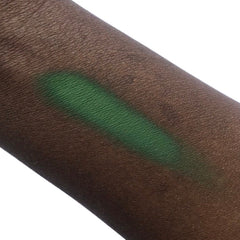 Green eyeshadow swatch on dark skin, showing color and texture on arm