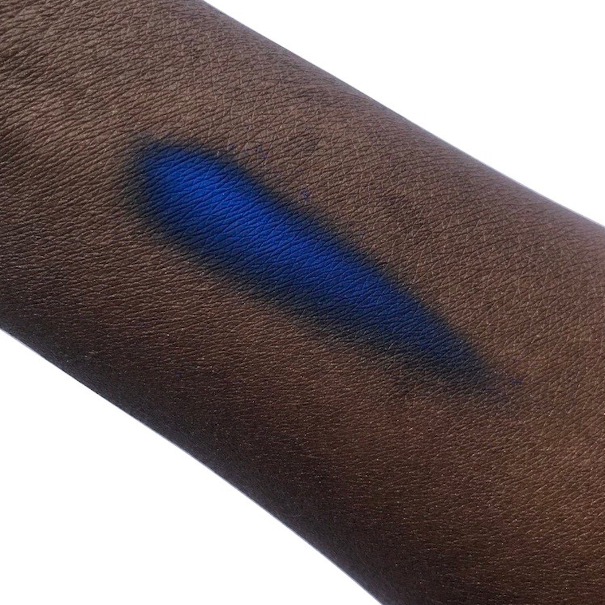 Blue swatch on dark skin, showing color and texture of the skin