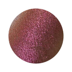 Close-up of NEBULA multichrome eyeshadow pot showing vibrant orange-pink-gold-violet shift in sunlight.