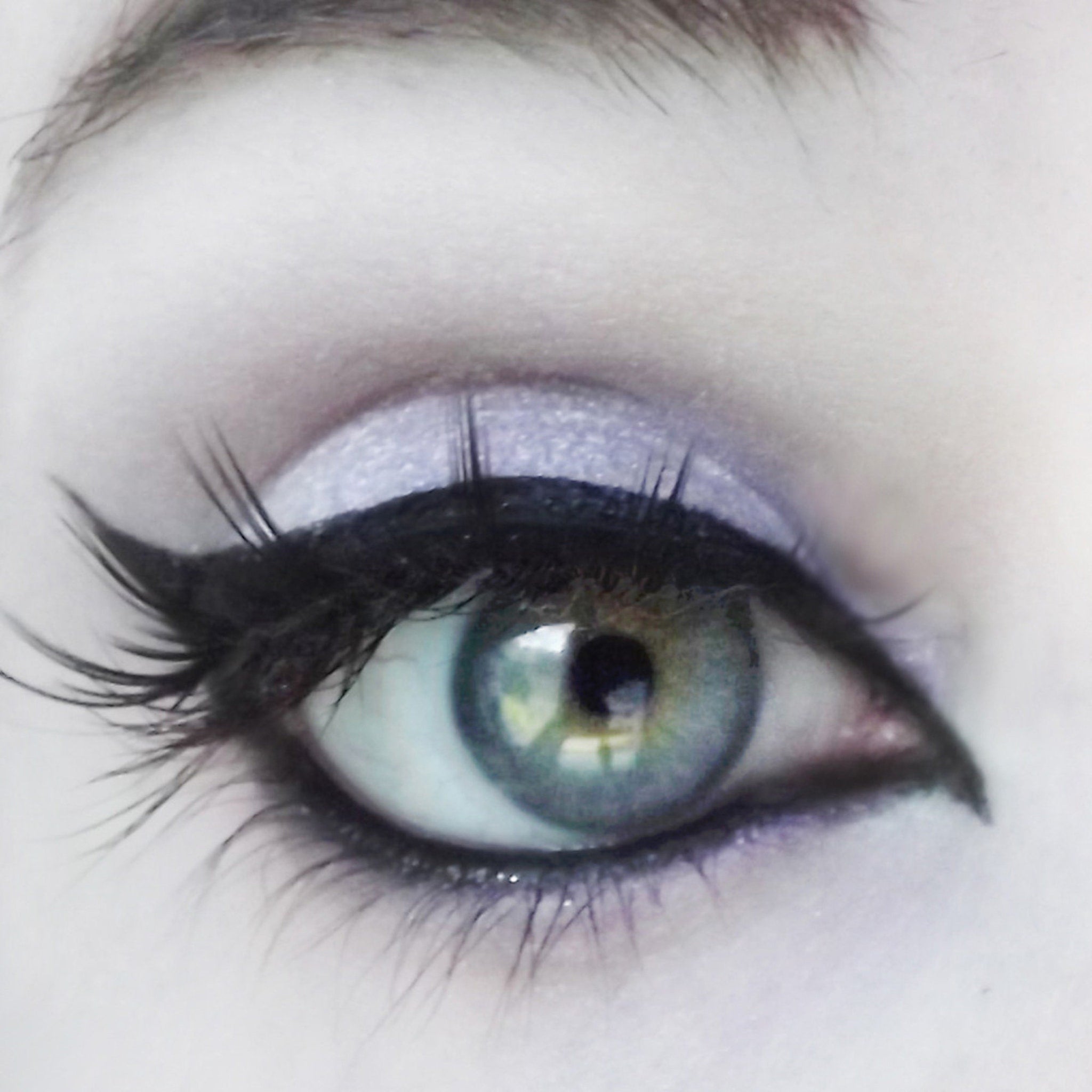 Eye makeup with blue-green eye, black eyeliner, and lavender eyeshadow for a dramatic look