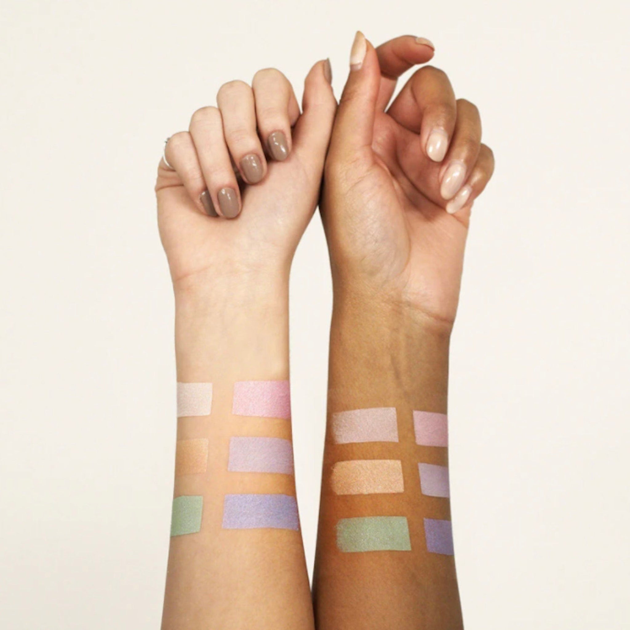 Makeup swatches on arms in various pastel colors and textures, shown for color comparison