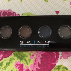 Close-up of SKINN Patina Eye Shadows palette showing six matte and shimmer powder shades in neutral tones