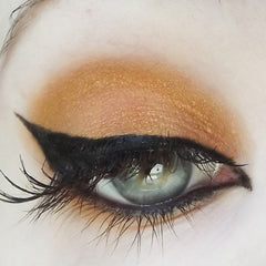 Eyeliner and eyeshadow: black winged eyeliner, gold eyeshadow, green eye with long lashes