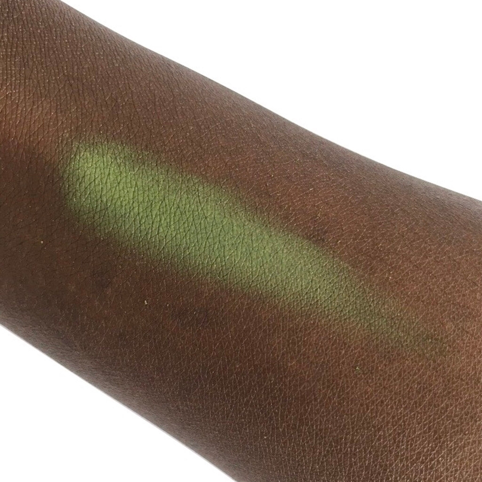 Eyeshadow swatch showing green pigment on brown skin