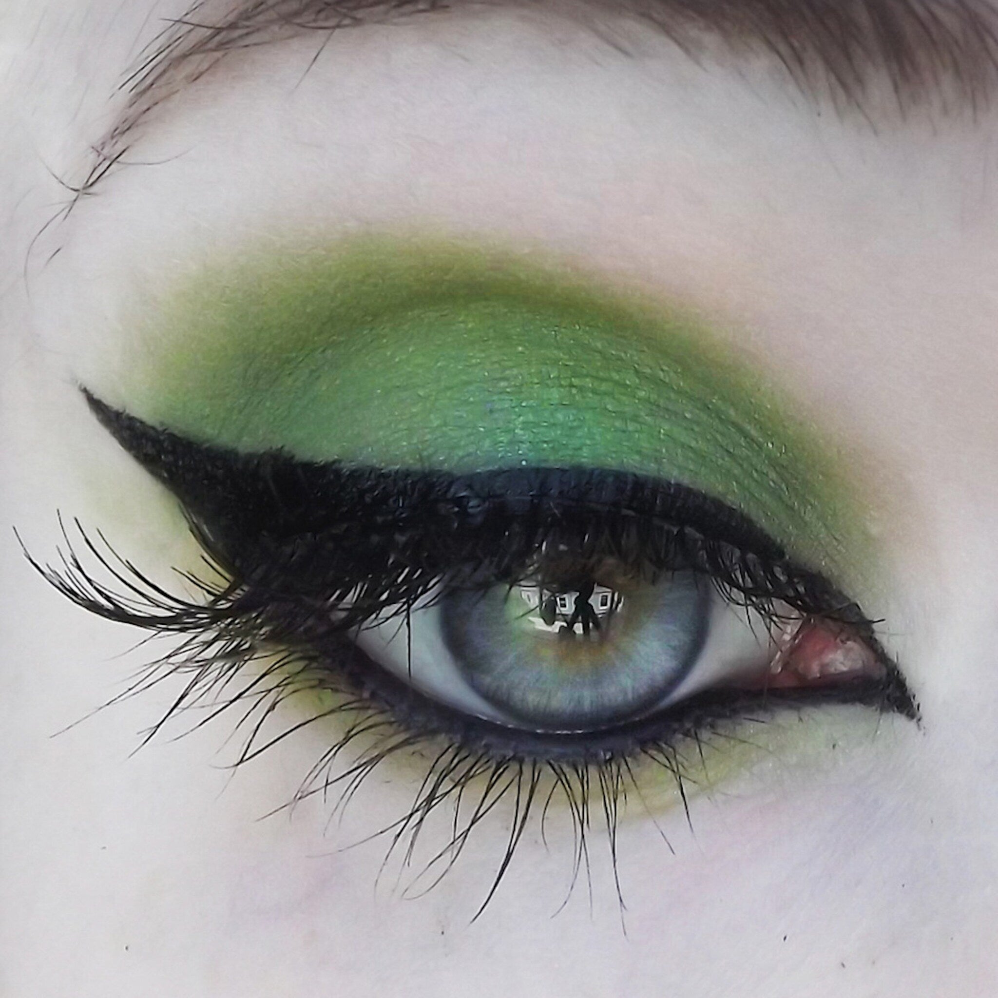 Green eyeshadow with black eyeliner and long eyelashes, eye makeup look