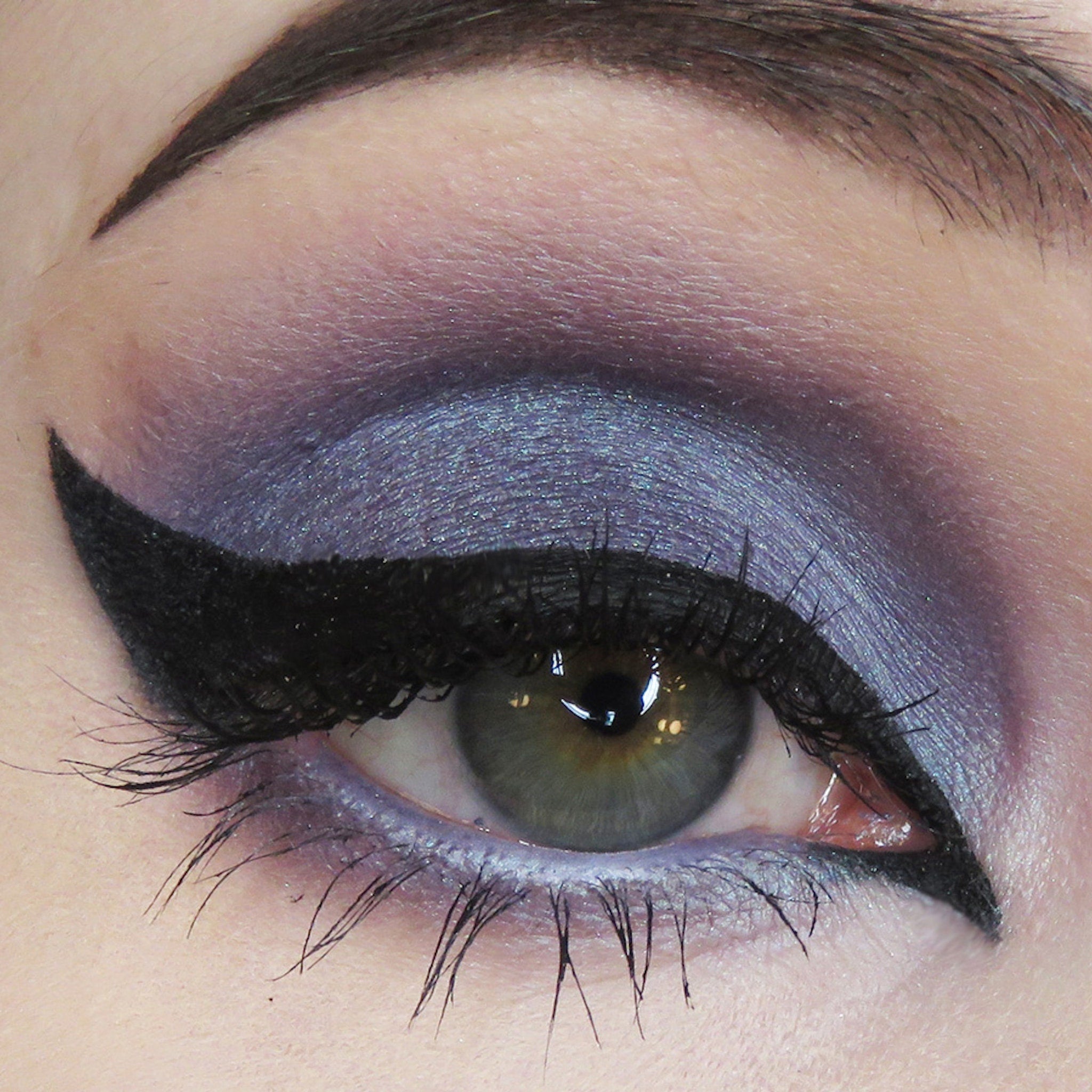 Eyeliner and eyeshadow makeup with black eyeliner and purple eyeshadow applied to eye