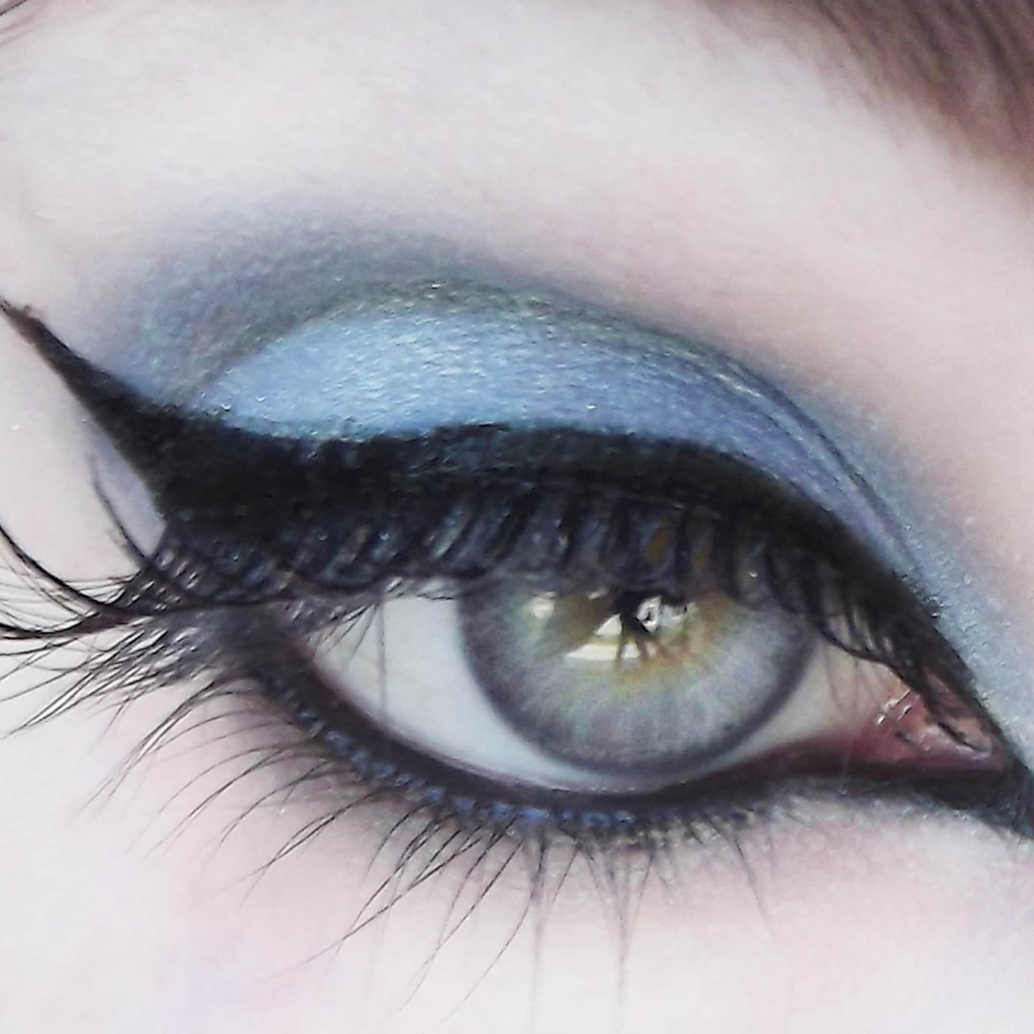 Eyeliner with black wing, blue eyeshadow, and gray eye color for makeup look