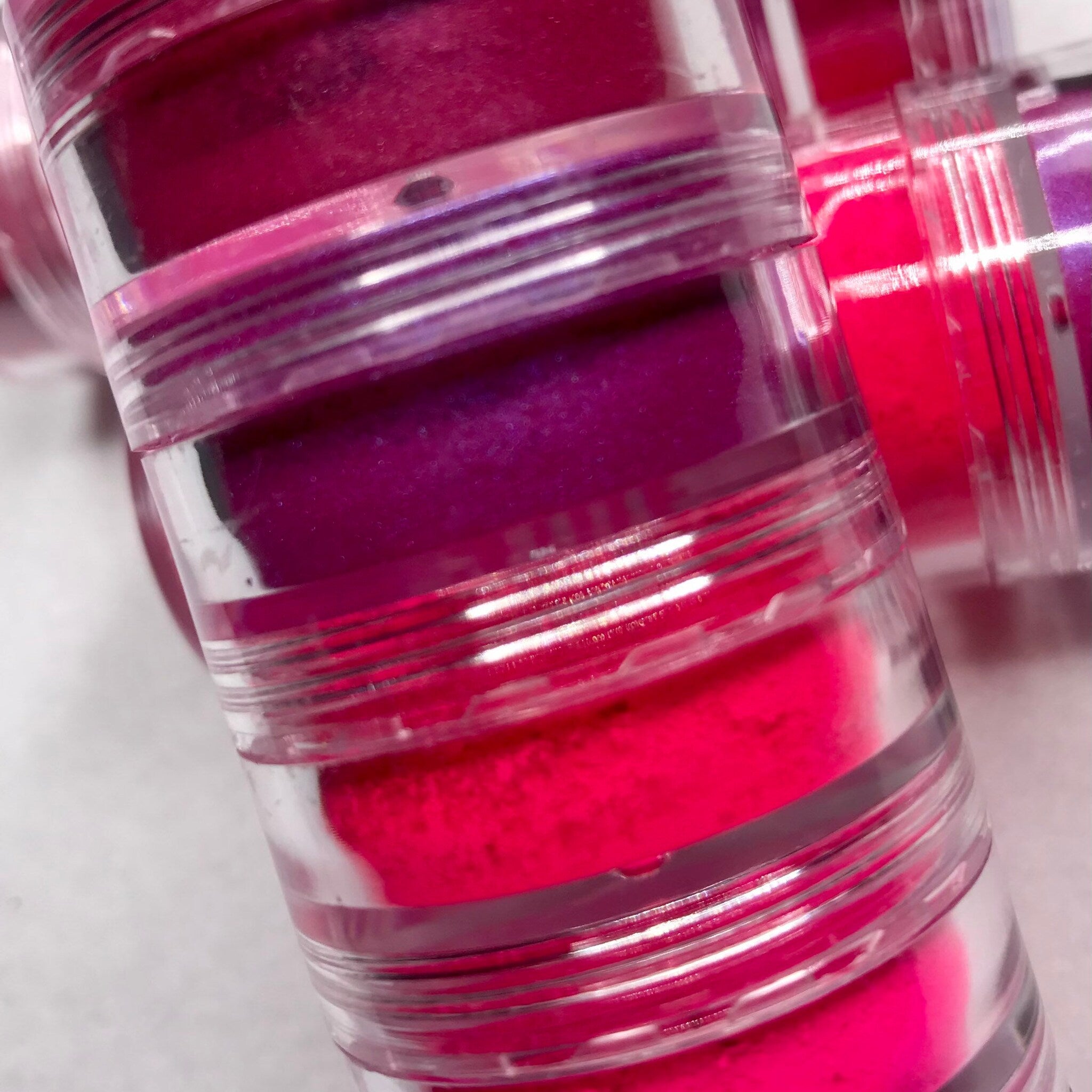 Side view of neon pink eyeshadow palette showing six vibrant matte and shimmer shades in rectangular pans