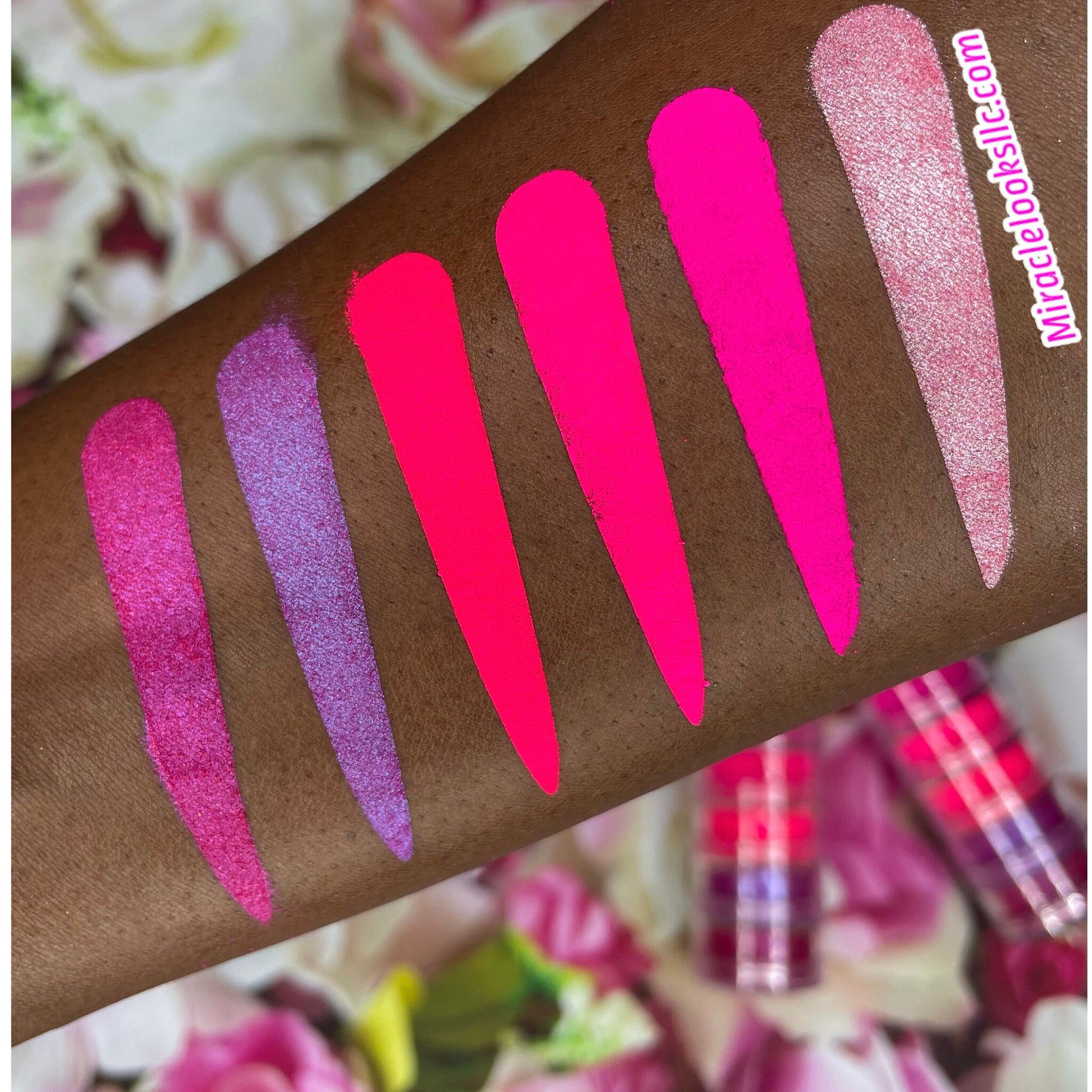 Open compact displaying six neon pink matte and shimmer eyeshadows in rectangular pans with mirrored interior.