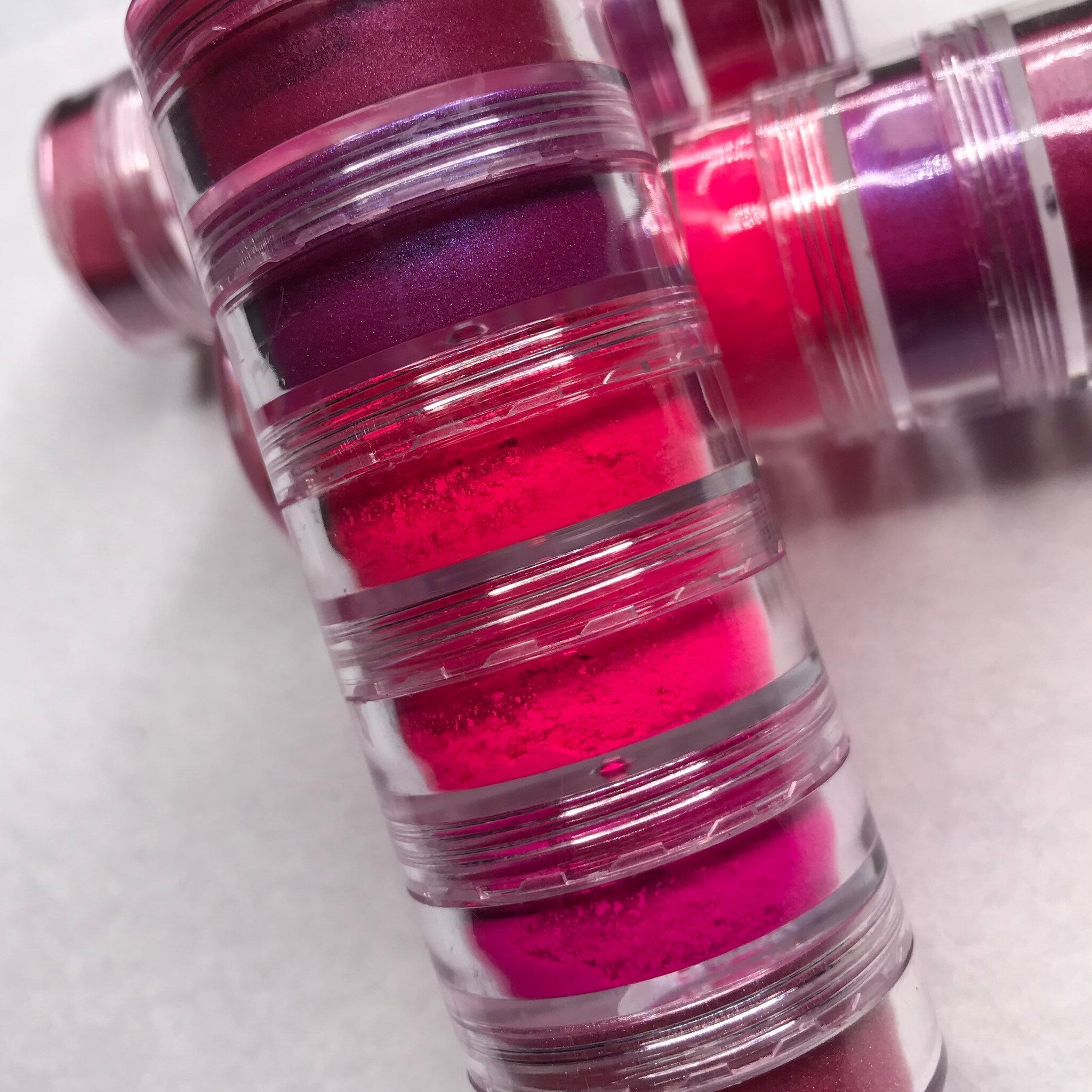 Close-up of neon pink eyeshadow palette showing six vibrant matte and shimmer shades in circular pans