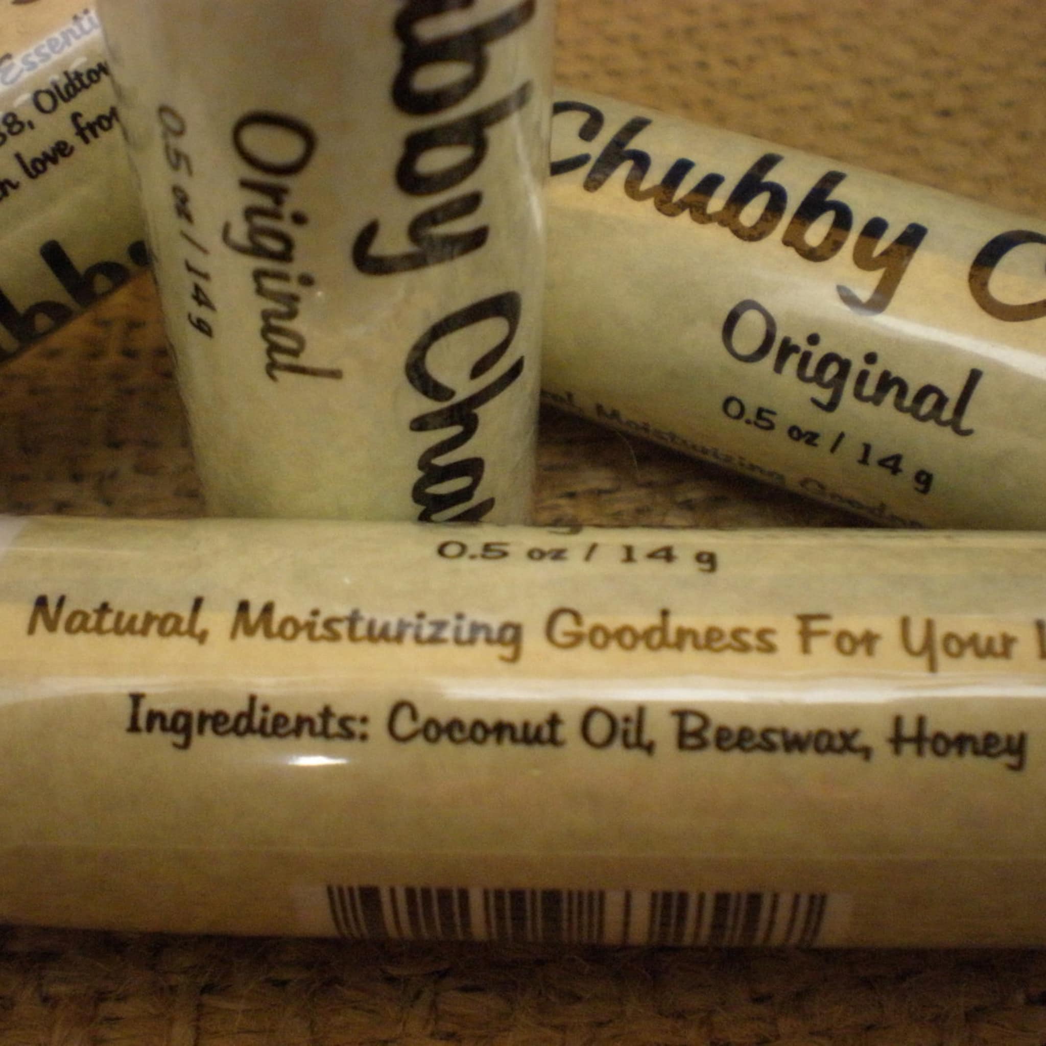Lip balm tubes with beige paper, black text, and Chubby Chap brand name visible