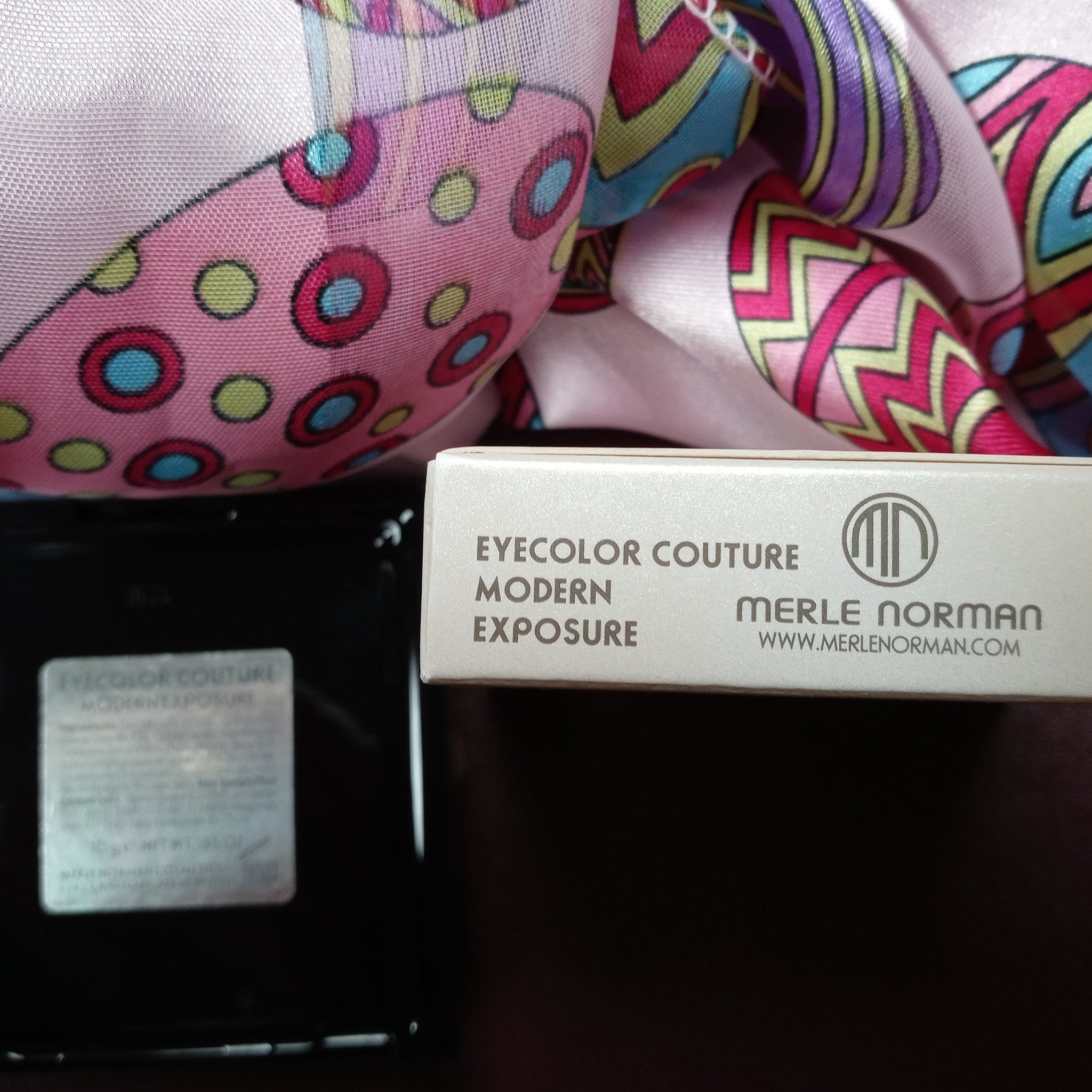Eye shadow box with Merle Norman text, pink and patterned fabric, black container