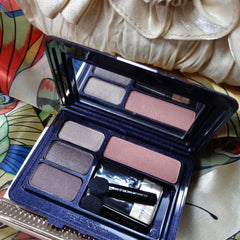 Eyeshadow palette with multiple shades of brown and pink, Merle Norman brand, with applicators