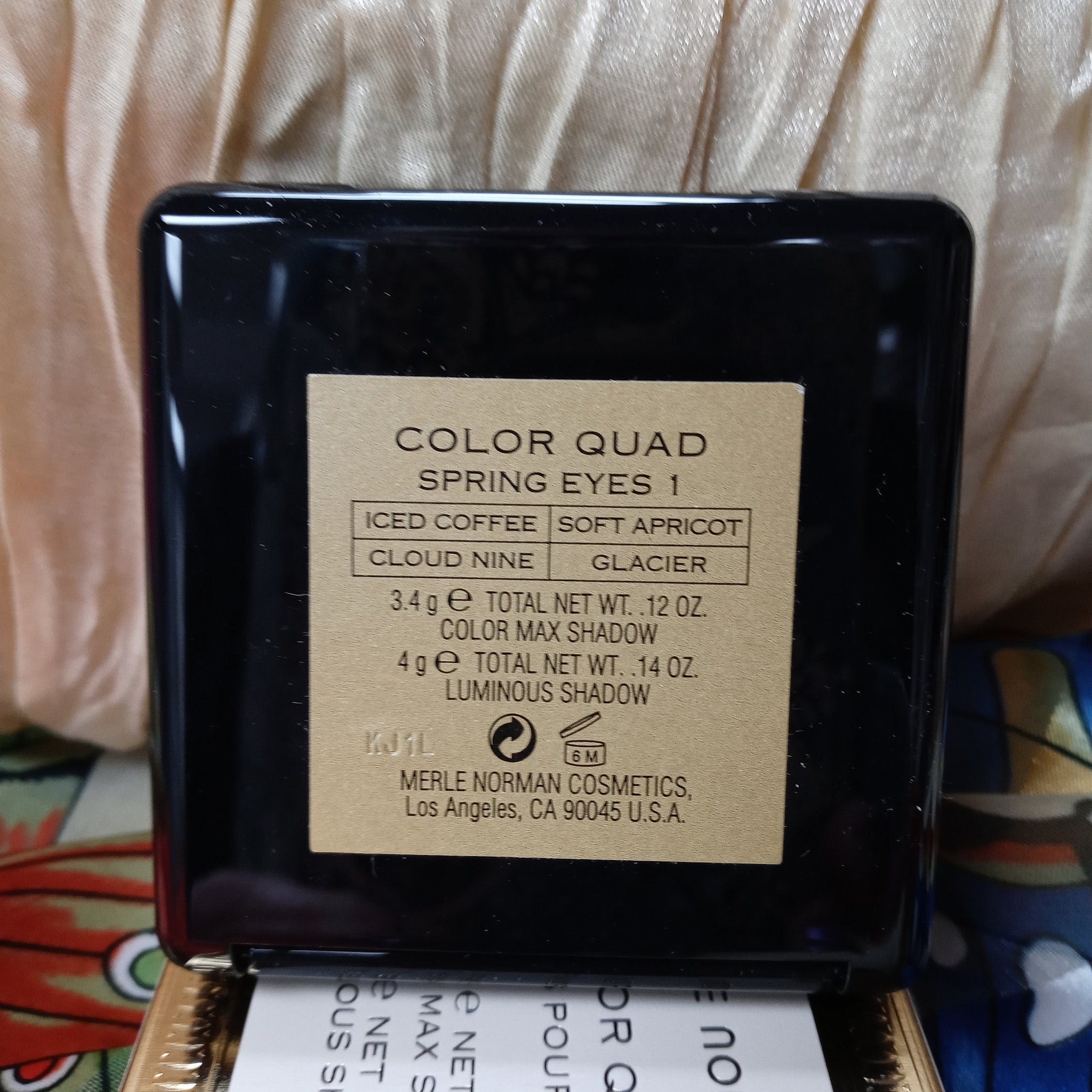 Side view of Merle Norman Eye Color Quad showing four pressed powder shadows in a sleek black compact