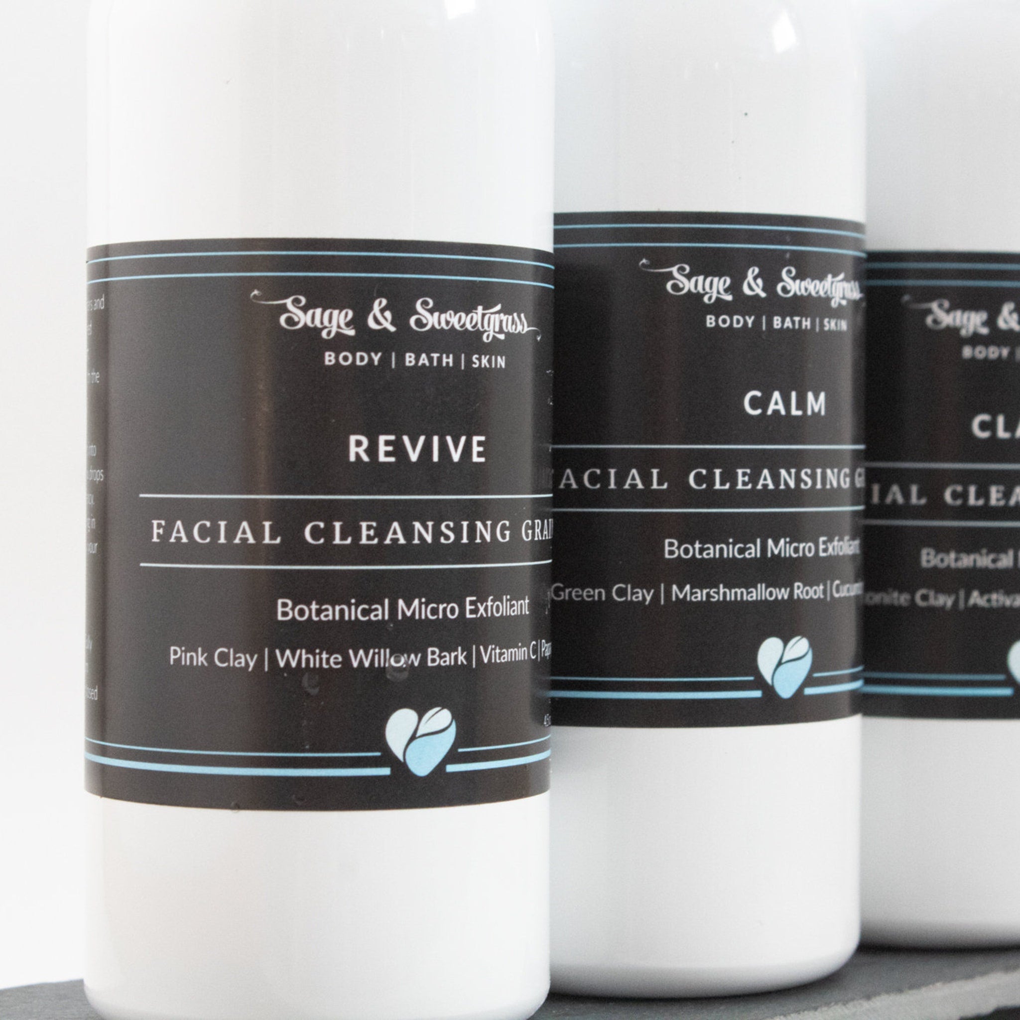 Facial cleansing grains in white bottles with black labels, Revive product name