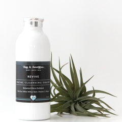 Facial cleansing grains in white bottle with black label and silver cap, Sage & Sweetgrass brand